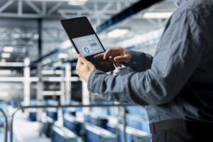 close up server room employee analyzing equipment metrics device screen